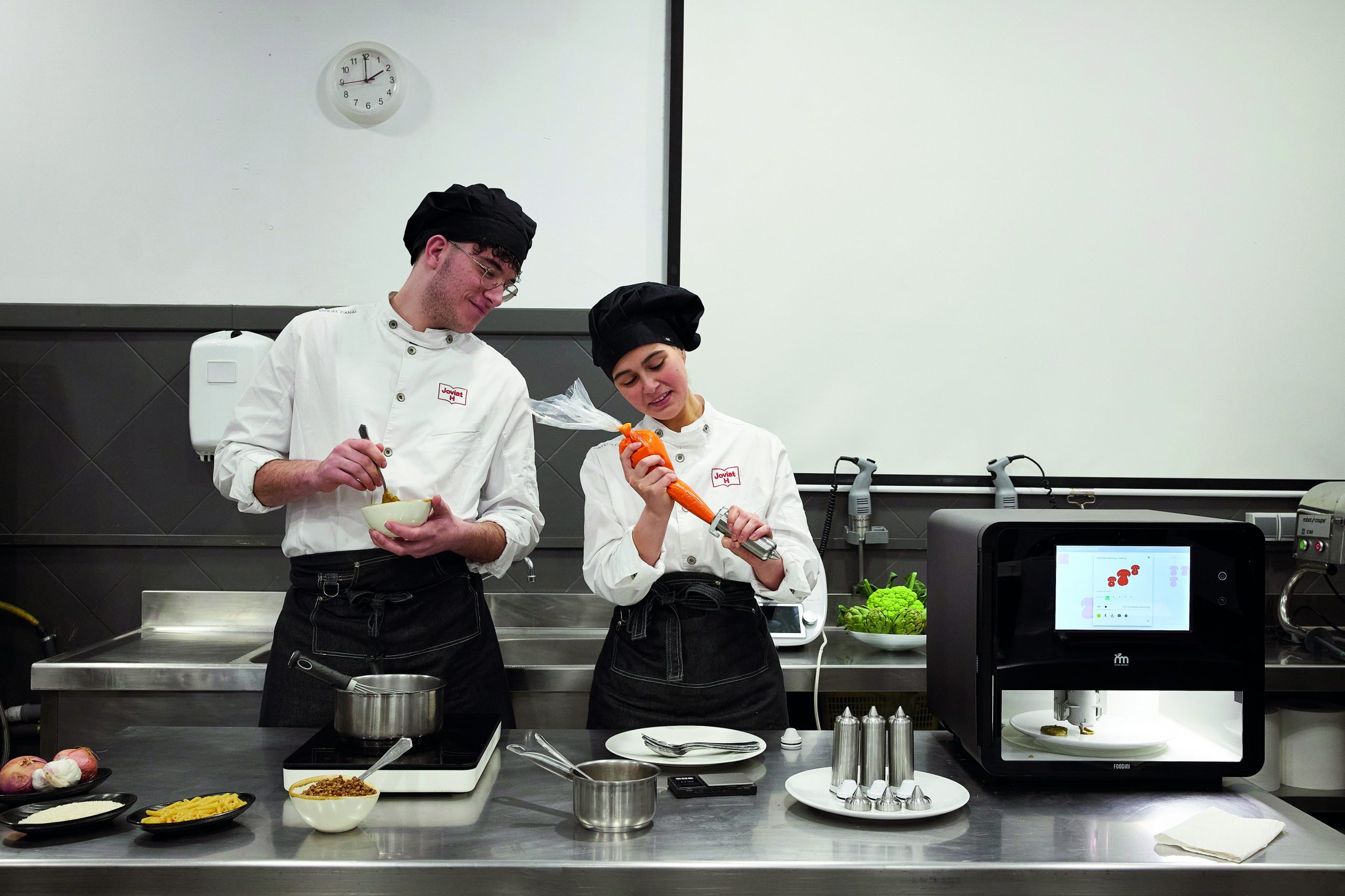 Dos estudiantes experimentand con la impresora 3D de comida